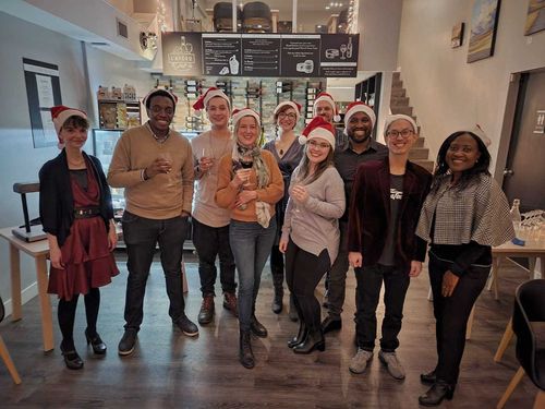 The team wearing Santa hats raising glasses of wine at our annual holiday party