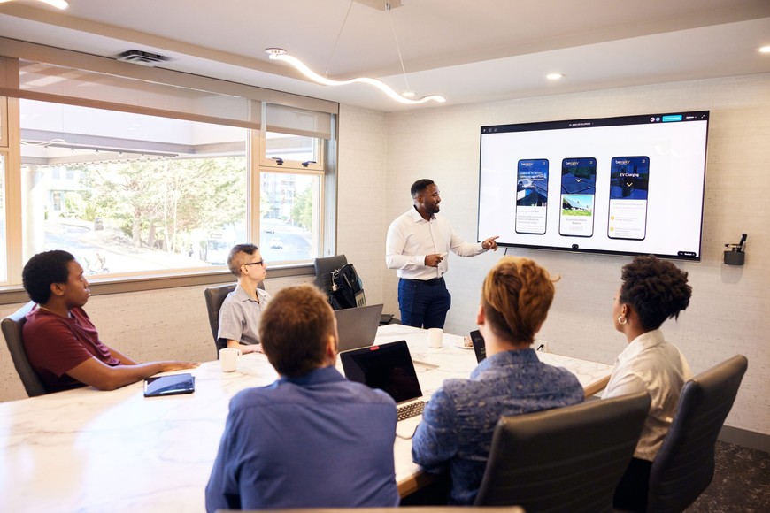 James presenting UX designs to the team in a board room.